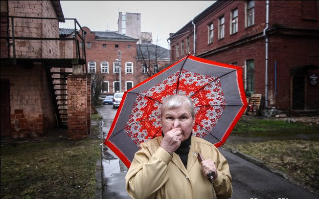 Женщина с зонтиком во дворе по улице Комсомольской. Фото Сергей Гудилин. nn.by